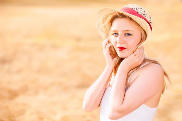 Ensam vacker ung blond flicka i vit klänning med stråhatt — Stockfoto