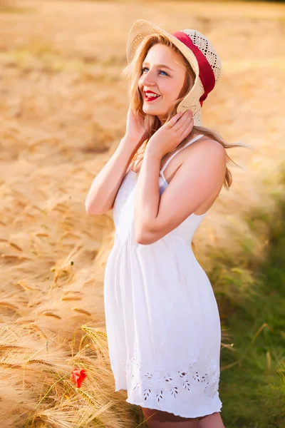 Eenzame mooie jonge blonde meisje in witte jurk met stro hoed — Stockfoto