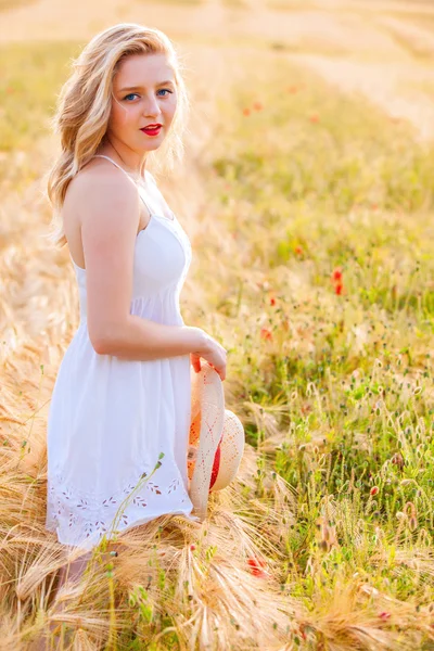 Lonely beautiful young blonde girl in white dress with straw hat — Stock Photo, Image