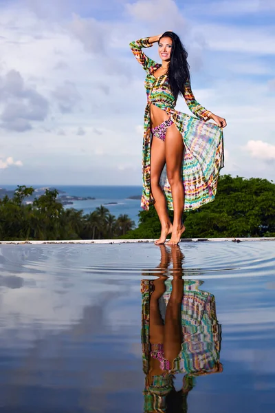 Bonita modelo morena en bikini posando en la piscina — Foto de Stock