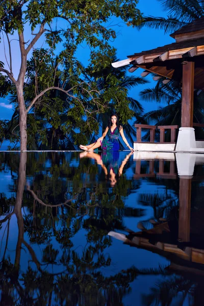 Modelo morena bonita em vestido de praia posando na piscina — Fotografia de Stock