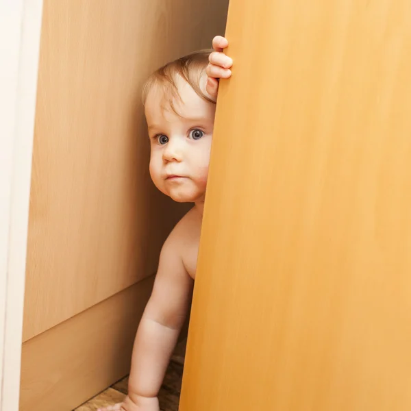 Boy looking through ajar door — Stock Photo, Image