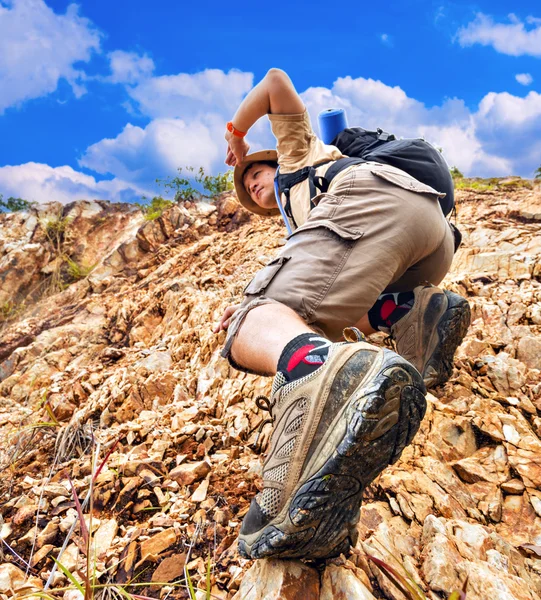 男子爬上红色岩石 — 图库照片