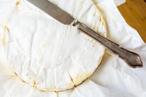 Kağıt ahşap t vintage bıçak ile sarılmış Camembert peyniri — Stok fotoğraf