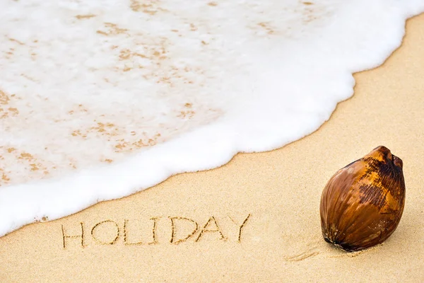 Napis słowo wakacje napisane na piasku — Zdjęcie stockowe