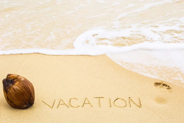 Napis słowo wakacje napisane na piasku — Zdjęcie stockowe