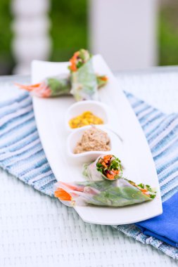 Vietnamese spring rolls with vegetables and coriander on a plate clipart