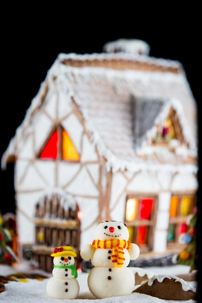 Dekorative Zuckerschneemänner und Lebkuchenhaus — Stockfoto