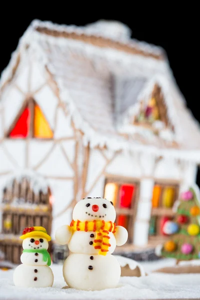 Decorative sugar snowmen and Gingerbread house — Stock Photo, Image