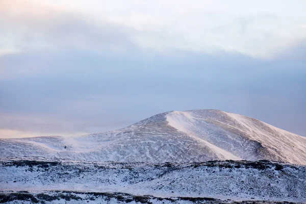 Snöiga Isländska bergen med dramatiska molnig himmel — Stockfoto