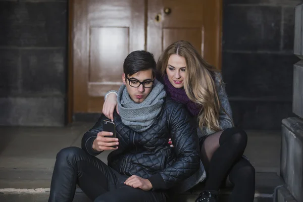 Junges Paar schaut aufs Smartphone — Stockfoto