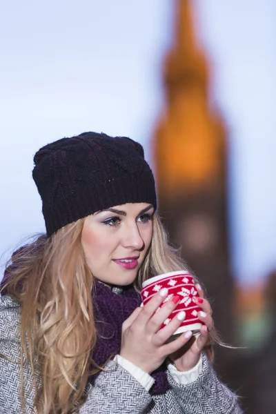 Blonde girl drinks hot drink — Stock Photo, Image