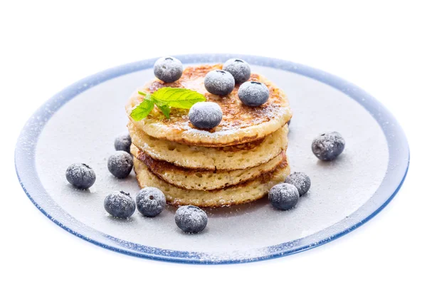 Pile of pancakes with blueberries sprinkled with icing sugar — Stock Photo, Image