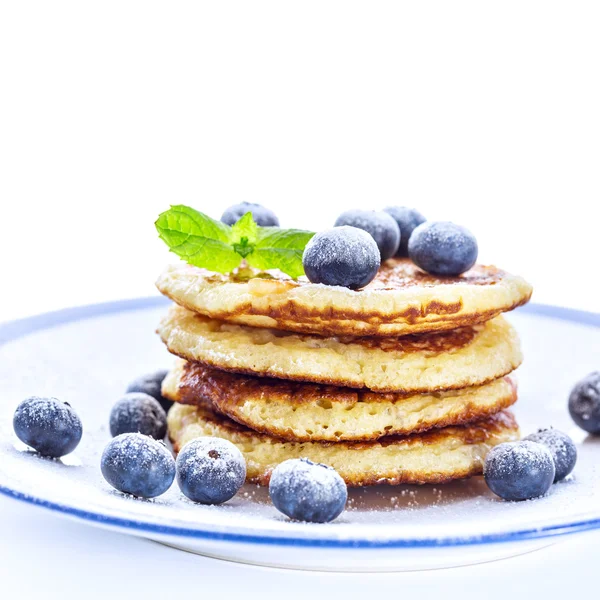 Pile of pancakes with blueberries sprinkled with icing sugar — Stock Photo, Image