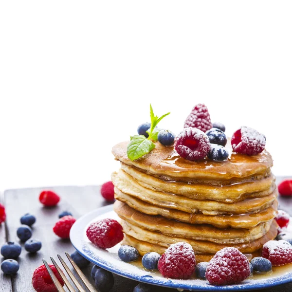 Pancakes with honey and berries on white background — Stock Photo, Image