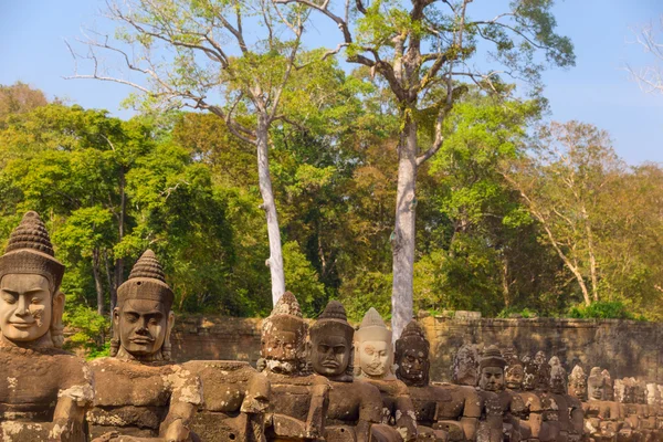 Des statues d'anciennes têtes de guerriers khmers portent un décorat de serpent géant — Photo