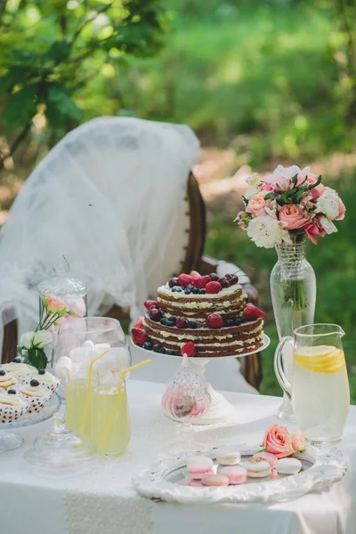 Украшенный сладкий стол для летнего свадебного пикника со сладостями, чашкой — стоковое фото