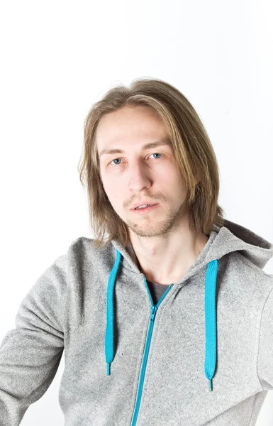 Портрет молодого человека с длинными светлыми волосами на белом фоне — стоковое фото