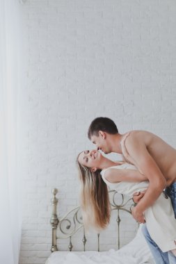 Yatak odasında genç çekici mutlu sevdalı Çift