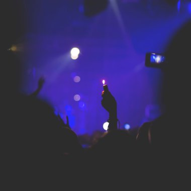 kalabalık tezahürat ve bir grup sahnede izlerken,