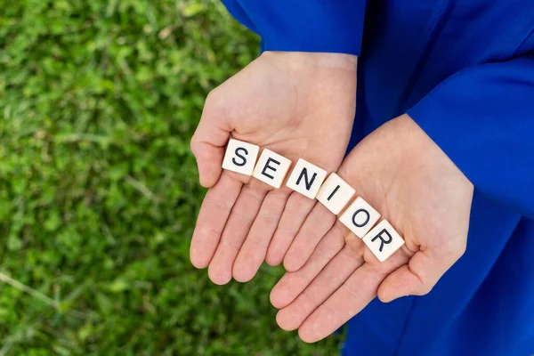 a senior holding the letters in their hands