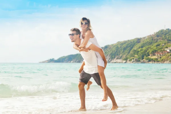 Beau jeune couple marchant le long du rivage d'une mer tropicale — Photo