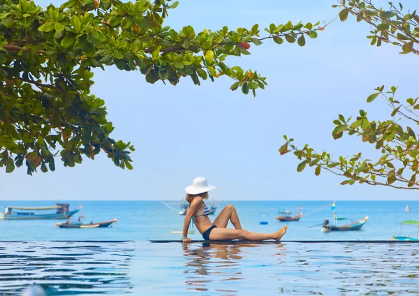 Mujer joven en bikini y sombrero en la piscina con vista al mar —  Fotos de Stock