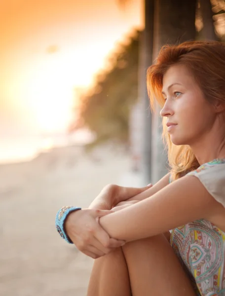 Mladá atraktivní blondýna na pláži pozorovat západ slunce — Stock fotografie