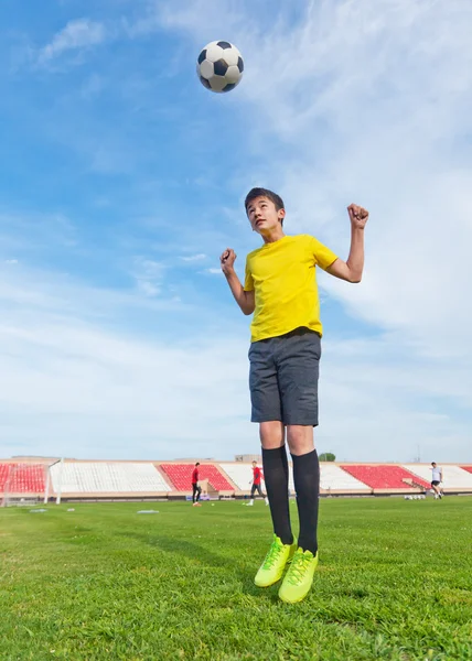 Adolescente asiático en un estadio de fútbol, practicando. Saltar y —  Fotos de Stock
