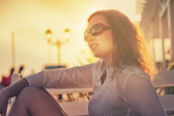 Portret van een jonge aantrekkelijke vrouw met krullend rood haar in zonnen — Stockfoto