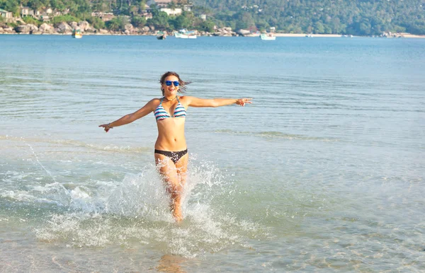 Счастливая молодая женщина прыгает в морскую воду. Счастье, свобода — стоковое фото