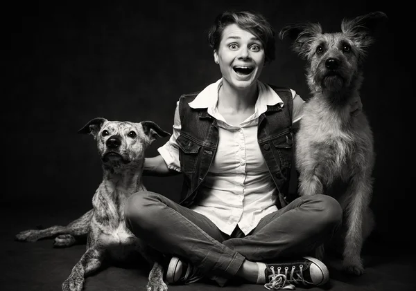 Piękna młoda kobieta z dwóch śmieszne psy na ciemnym tle. — Zdjęcie stockowe
