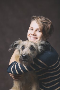 Koyu bir backgrou tarihinde Komik tüylü köpek olan güzel kadın