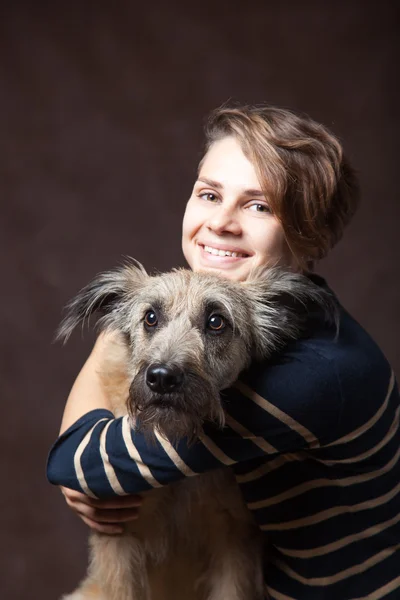 Koyu bir backgrou tarihinde Komik tüylü köpek olan güzel kadın — Stok fotoğraf