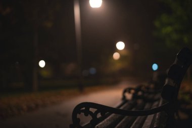 Geceleri bir sonbahar parkında fener ışığında banklarla.