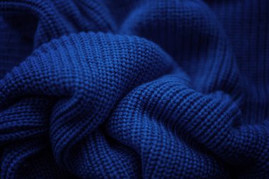 Mavi örülmüş sıcak süveter dokusu, parlak ve soyut bir arka plan.