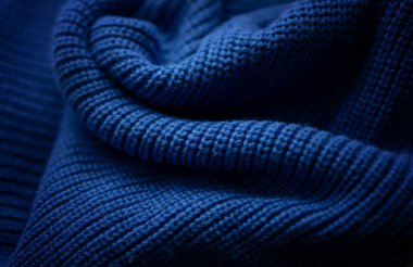 Mavi örülmüş sıcak süveter dokusu, parlak ve soyut bir arka plan.