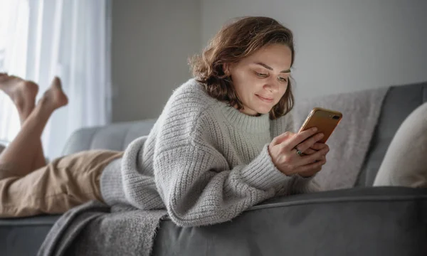 Jovem Mulher Encaracolado Feliz Camisola Cinza Deitado Sofá Vídeo Conversando — Fotografia de Stock