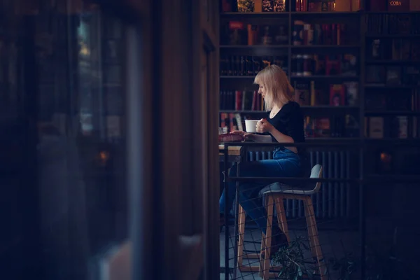 Vacker Ung Blond Kvinna Sitter Mysiga Café Med Bokhyllor Dricka — Stockfoto