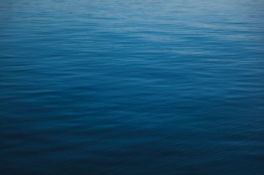 Güzel mavi deniz suyunun pürüzsüz dalgaları, yüzeyi ve soyut doğal arkaplanı.