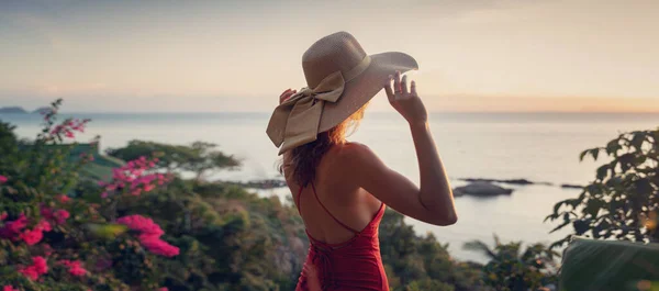 若いです美しいです陽気な女性でビキニと帽子楽しむ熱帯休暇とともに夕日の海の景色 — ストック写真