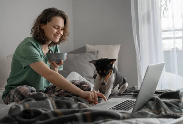 Счастливая Молодая Женщина Себя Дома Завтракает Кровати Пижаме Перед Ноутбуком — стоковое фото