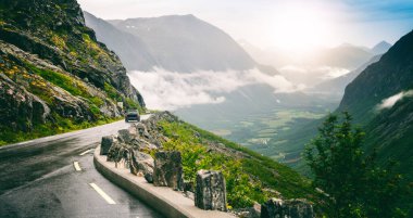 Yoldaki araba Norveç 'teki Geiranger' e doğru Trollstigen, yağmur ve palyaço havası, güzel manzara