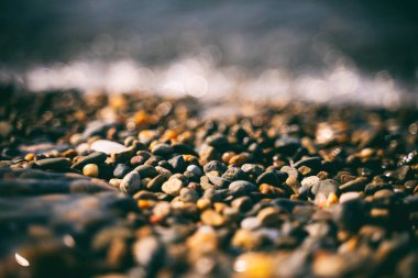 Çakıl taşı plajı, deniz kıyısı. Çakıl taşları, bokeh ve yumuşak odaklı yakın çekim. Doğa Denizi