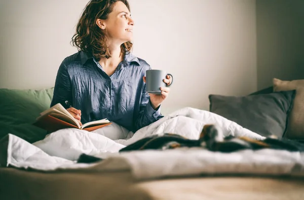 Ung Glad Kvinna Sitter Sängen Och Skriver Dagbok Och Dricker — Stockfoto