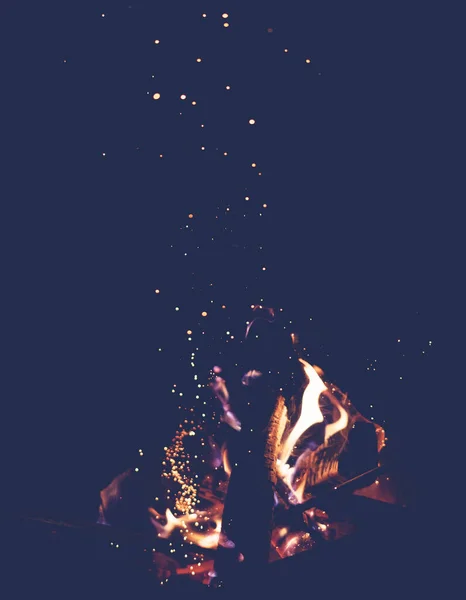 Lángoló tábortűz repülő szikrák sötét háttér, függőleges kép — Stock Fotó