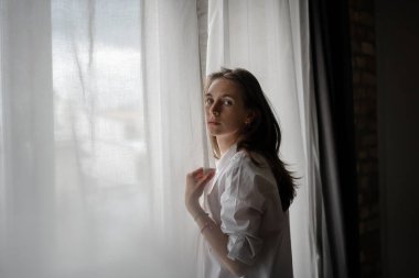 Beyaz gömlekli, uzun saçlı, güzel, şehvetli genç bir kadın.