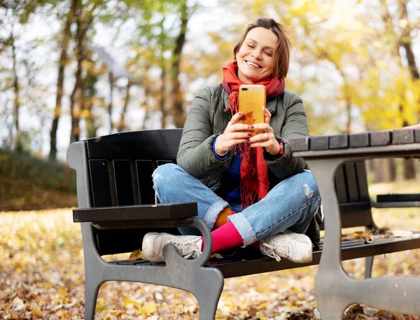 Młoda Dorosła Szczęśliwa Kobieta Lat Jasnych Ubraniach Siedzi Jesiennym Parku — Zdjęcie stockowe
