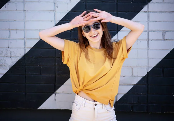 Portret Młodej Szczęśliwej Kobiety Okularach Przeciwsłonecznych Żółtej Koszulce Ulicy Tle — Zdjęcie stockowe