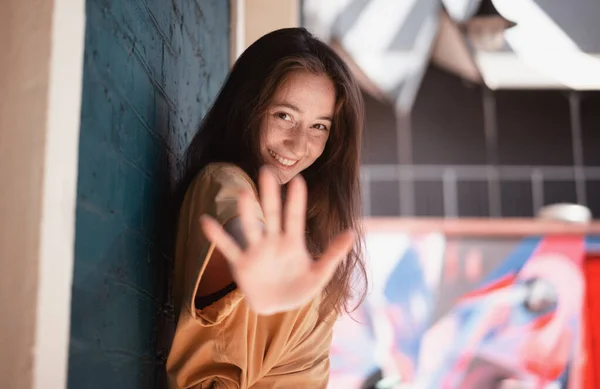 Портрет молодой счастливой девушки в солнечных очках на улице города протягивающей руку к камере, портрет в городском стиле — стоковое фото